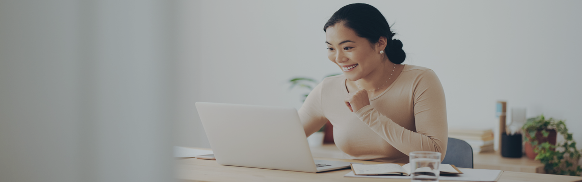 Annual Report Header. Woman looking at laptop smiling