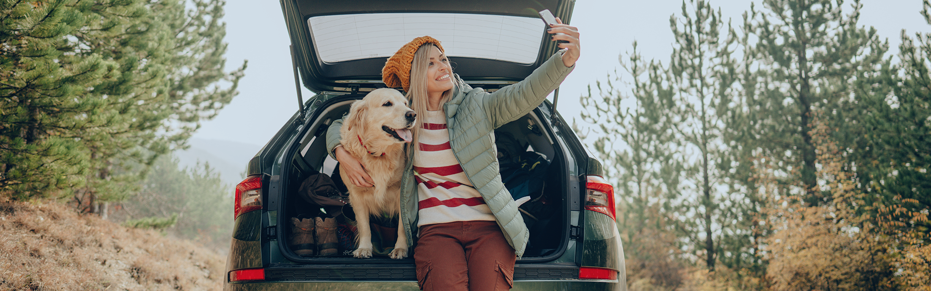 Woman and dog taking a selfie in the trunk of a car.