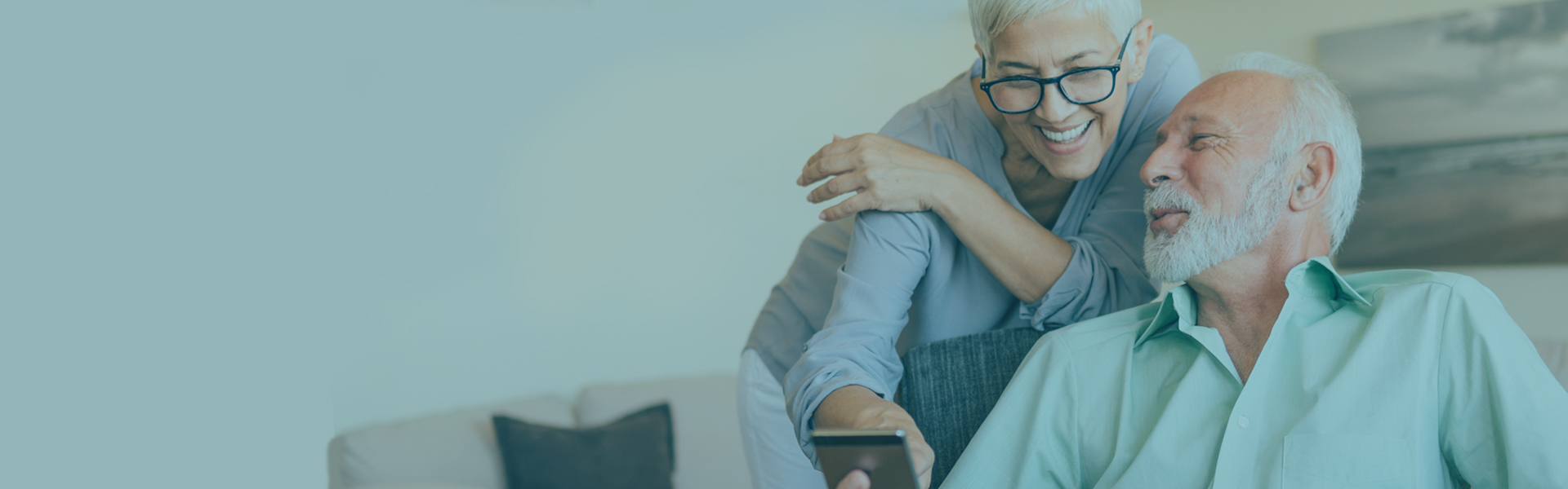 Senior couple laughing at phone | Communications