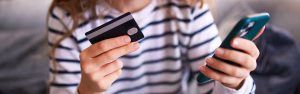 Girl looking at phone and credit cards.