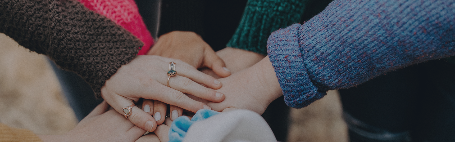 Group of hands reaching to meet in the middle