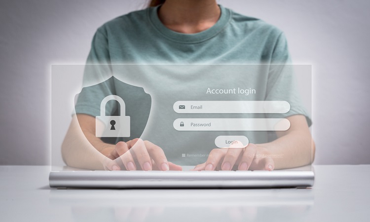 Man wearing a green shirt typing on laptop. Popup screen displays username and password input,