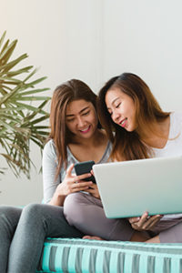 Two girls on laptop, financial independence