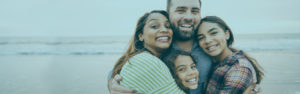 Family hugging on beach | Member Services