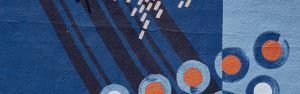 Blue and orange design on brick wall for Upcoming Merger page.