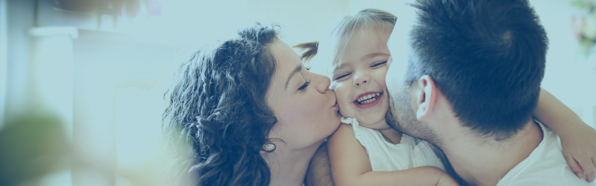 Share Savings Hero | Family kissing small child