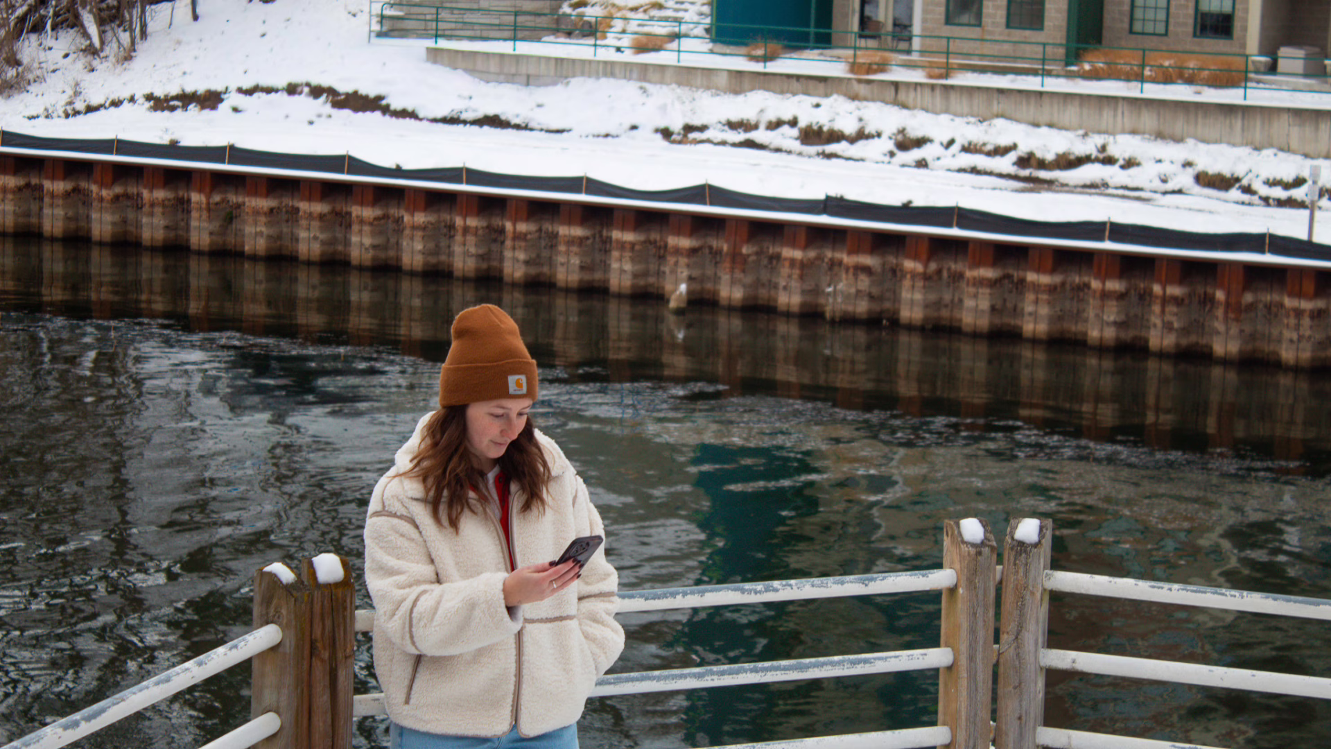 Girl looking at phone in the winter.